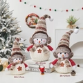 Three plush Christmas snowman dolls with knit hats and scarves in a cozy holiday scene - Three-Piece Set / Brown Earmuff Snowman Family of Three