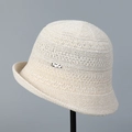 Détail d'un chapeau de soleil en tricot beige avec texture fine et petit logo latéral - M (56-58cm) / Beige
