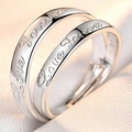 Close-up of silver couple rings engraved with Love Forever on soft white fabric - Forever Love