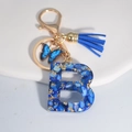 Blue resin letter B keychain with tassel, butterfly charm and gold foil accents - Letter B