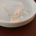 Macro shot of silver U-shaped oval earrings with black engraved lettering in a white dish - Letter Engraved Hoop (Silver)
