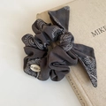 Detail of charcoal gray paisley bandana hair scrunchie with BOTANI brand label - Bowknot Style / Gray