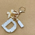 Letter D resin keychain with white stone, gold foil, metal butterfly and tassel - Letter D