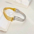 Detail of two-tone gold and silver steel bangle featuring parallel lines and bead accents - Round Beads