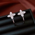 Primer plano de pendientes de flor en forma de C con circonitas en un joyero negro - Aguja de Plata S925/Cobre Bañado en Plata / Plateado