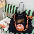 Close-up of black nylon tote with sweet donut embroidery and colorful woven rope detail - Black Delicious Donut (Without Shoulder Strap)