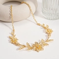 Detailed close-up of golden floral necklace with engraved leaf texture and crystal centers - Gold Flower