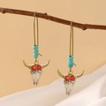 Detail von böhmischen Stierkopf-Ohrringen mit Türkisperlen an einem trockenen Holzzweig - Rote Blume Stierkopf Türkis Ohrhaken (A-75) / Hellgold