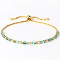 Detailed shot of a gold bracelet featuring blue baguette stones and clear round crystals - Sea Blue Zircon Gold