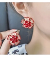 Detalle macro de pendientes de flor roja con pétalos de circón blanco brillante - Rojo