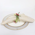 Detail van een kerst servetring met dennennaalden en rode bessen op een wit bord - Bevroren wit gewei dennenaald rode bes