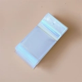 Vista macro de bolsas de embalaje de plástico transparente apiladas en una mesa - 6*12cm-Con Orificio de Suspensión-Doble Capa 90 Micrones (100 Piezas/Paquete)