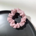 Close-up of pink satin scrunchie with silky texture on a minimalist black tray - Light Pink