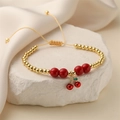 Detail of beaded bracelet with red cherry charm and adjustable yellow woven cord - Gold & Red Beads with Cherry Pendant (E000441YS)