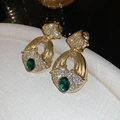 Detail of vintage gold earrings with green gemstones and white crystals on a pedestal - 22# Vintage Gold Base Green Gem Ear Clip