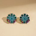 Close-up of geometric flower earrings with green and blue crystals on beige leather - Blue Stud Earrings (Silver Pin)