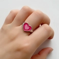 Close-up of a double-layered pink enamel heart ring on a finger with a silver band - US 6 / Pink 18K Gold