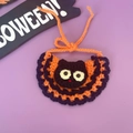 Detail van de handgebreide Halloween-slabbetje voor huisdieren met zwart kattenontwerp - Katzenkop Slabbetje