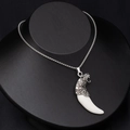 Detailed close-up of a vintage tiger head and white wolf tooth pendant on a bead chain - Tiger Head with White Tooth