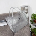 Close-up of semi-transparent white hollow mesh basket bag on a grey fabric background - Small Transparent