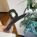 Detail of large black hair claw clip with glossy finish and strong golden spring - Dark Gray