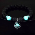 Vista macro del bracciale loto luminoso con pietre laviche nere e perle turchesi - 10mm Pietra Lavica con Luce Blu-Verde