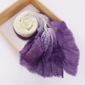 Dettaglio di sciarpa tie-dye viola e bianca con frange su un vassoio di legno chiaro - Sfumato Viola Bianco