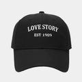 Detailed close-up of white LOVE STORY 3D embroidery on a black cotton baseball cap - Adjustable / Black