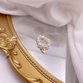 Macro shot of freshwater pearl ring with gold V pendant on vintage mirror - Letter V