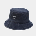 Detail of navy washed cotton bucket hat showing heart embroidery and metal eyelet - Navy Blue
