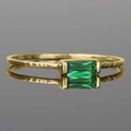 Detailed macro view of gold hammered ring band with rectangular green emerald gemstone - Green