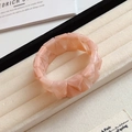 Dettaglio ravvicinato di perle triangolari in acrilico rosa su un bracciale elastico - Stile Sfaccettato Geometrico / Rosa Pesca (Marmorizzato)