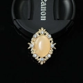 Macro detail of oval alloy charm with yellow cat eye stone and sparkling crystals - Cat's Eye