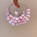 Primer plano de pendientes de aro plateados con borlas de nácar rosa para vacaciones - Aro de Plata Concha Rosa