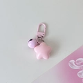 Detailed macro view of pink star charm with a purple bell and painted metal hook - Pink