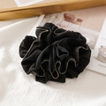 Dettaglio di un elastico per capelli nero con bordi a balze e perline dorate - Plissettato Nero