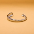 Macro detail of polished silver stainless steel open bangle with smooth retro lines - Silver Wide Minimalist Style (HZ47998AW0)
