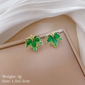 Macro shot of gold maple leaf stud earrings with green zircon stones on jewelry box - Green Maple Leaf Stud Earrings (E334)