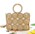 Detail view of woven straw tote bag with round hollow patterns and fabric lining - Light Brown with Beige Lining