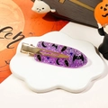 Detail of purple glitter Halloween hair clip with RIP coffin design on white tray - Purple Glitter Bat