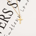 Detail shot of golden cross pendant necklace with classic O-chain on white background - Gold