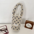 Detail of plush heart-patterned cup sleeve with soft lamb wool texture and handle - Beige with Blue Heart