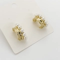 Close-up of golden textured earrings with multiple white pearls on a white display card - Gold