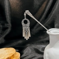 Detailed shot of silver turquoise hair stick with hollow flower and tassels on dark fabric - Silver/F228/Hollow Disc Tassel