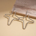 Detalle de pendientes de estrella plateados sobre piedra con diseño geométrico - Plateado