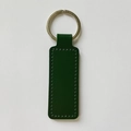 Close-up of green PU leather keychain with metal ring and visible double-sided stitching - Dark Green