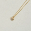 Dettaglio della collana dorata con ciondolo occhio del male e pietre in zirconia luminose - Bianco