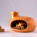 Ceramic Palo Santo holder in orange finish with burning wood sticks and subtle smoke - Brown Small House