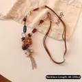 Close-up of bohemian pendant necklace with wood beads and engraved vintage star charms - Brown Bohemian Beaded Style