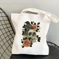 Vintage canvas tote bag with skull and rose print on a black mesh chair - Skull Raven Rose